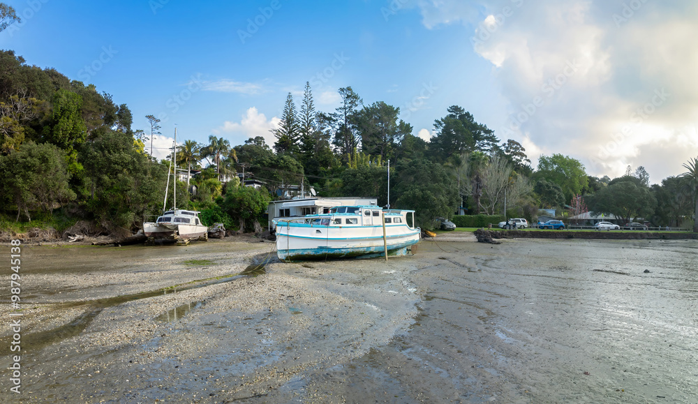 Boat at low tide resting in the sand at Laingholm, Auckland, New Zealand. Boat at low tide resting in the sand at Laingholm, Auckland, New Zealand.