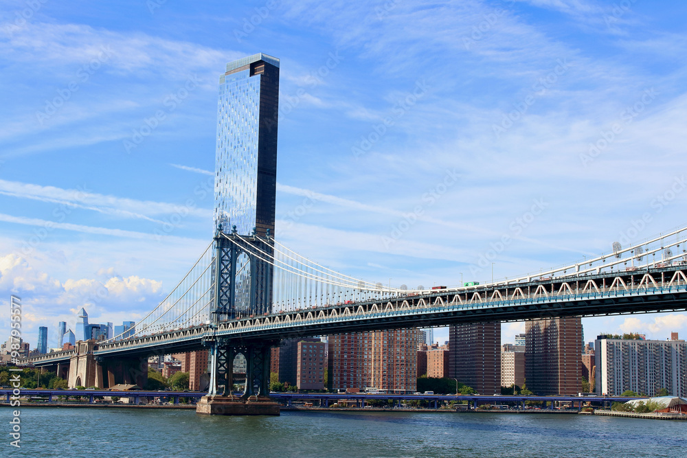 Fototapeta premium Main view of Manhattan bridge with iconic skyscrapers on background during a summer sunny day, NYC, USA.