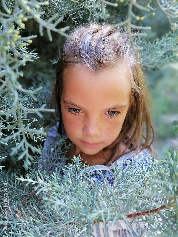 Little girl in the garden. Beautiful flowers roses. Cute lady watching thoughtfully. Child with big green eyes. Lovely flowers pink color. Green plant background. The charm of youth High quality photo Little girl in the garden. Beautiful flowers roses. Cute lady watching thoughtfully. Child with big green eyes. Lovely flowers pink color. Green plant background. The charm of youth High quality photo