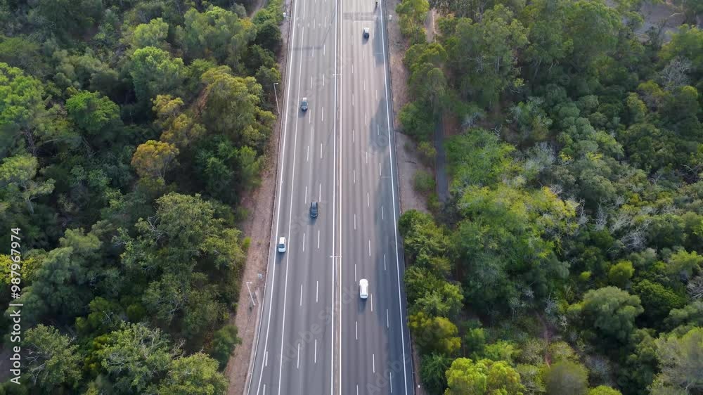 Autoestrada em Monsanto, Lisboa, ao pôr do sol com tráfego em movimento. O céu alaranjado ilumina a estrada e os veículos, criando um contraste entre a natureza e a paisagem urbana. Autoestrada em Monsanto, Lisboa, ao pôr do sol com tráfego em movimento. O céu alaranjado ilumina a estrada e os veículos, criando um contraste entre a natureza e a paisagem urbana.