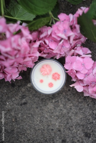 A handcrafted white soy candle featuring embedded pink flowers. This serene and aesthetically pleasing candle adds a touch of nature and elegance to any setting, ideal for wellness or home decor image