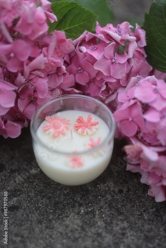 A handcrafted white soy candle featuring embedded pink flowers. This serene and aesthetically pleasing candle adds a touch of nature and elegance to any setting, ideal for wellness or home decor image