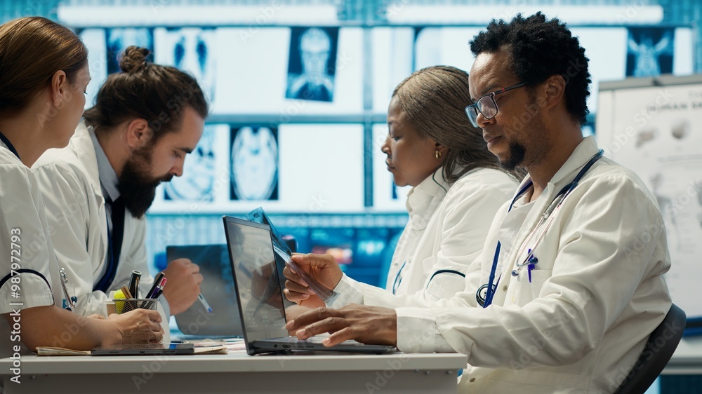 Physicians examining x ray scan results in a meeting with the staff, working to develop treatment plans. Doctors doing collective work for diagnostics control, healthcare industry. Camera A. Physicians examining x ray scan results in a meeting with the staff, working to develop treatment plans. Doctors doing collective work for diagnostics control, healthcare industry. Camera A.