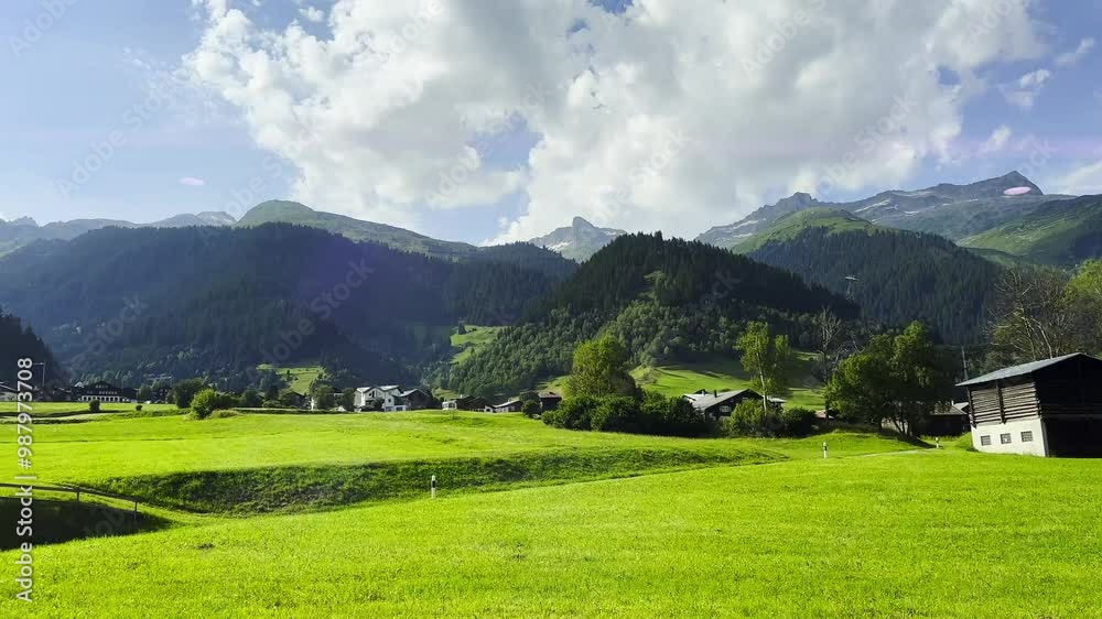 View From Glacier Express Train on a Beautiful Village and Mountainscape in a Mountain Valley in a Sunny Summer Day in Disentis, Muster, Surselva, Oberalp, Grisons, Switzerland, Europe View From Glacier Express Train on a Beautiful Village and Mountainscape in a Mountain Valley in a Sunny Summer Day in Disentis, Muster, Surselva, Oberalp, Grisons, Switzerland, Europe