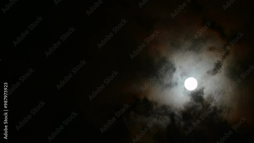 Clouds pass in front of the full moon, in this case the harvest moon Clouds pass in front of the full moon, in this case the harvest moon