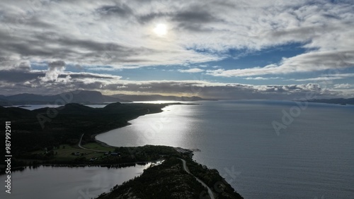 Scenic coastal landscape with sun shining through clouds.