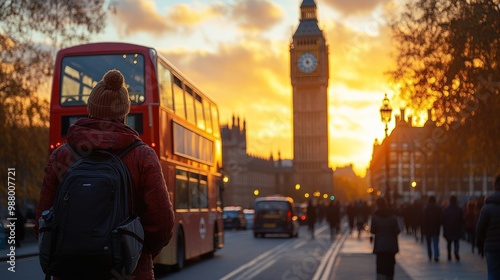 Sunset view of Big Ben with a red bus and pedestrians in London.
