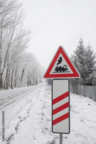 Traffic sign in front of railway crossing.Winter landscape.