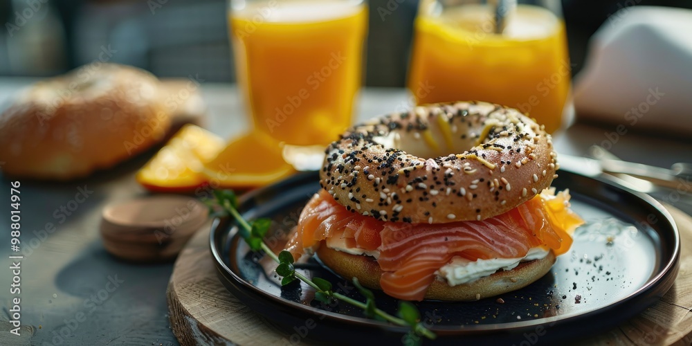 Bagel with salmon and cream cheese accompanied by freshly squeezed orange juice Bagel with salmon and cream cheese accompanied by freshly squeezed orange juice