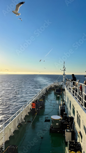 A beautiful morning view of a ship. This description captures a breathtaking morning view of a ship gently sailing across calm waters. The early sunlight bathes the vessel in a warm, golden glow. photo