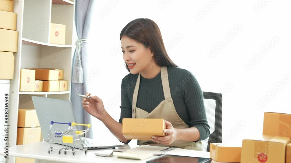 Female SME business owner entrepreneur working on receipt boxes and checking online orders to prepare to pack boxes, sell to customers. Online SME business concept, small business startup. Female SME business owner entrepreneur working on receipt boxes and checking online orders to prepare to pack boxes, sell to customers. Online SME business concept, small business startup.