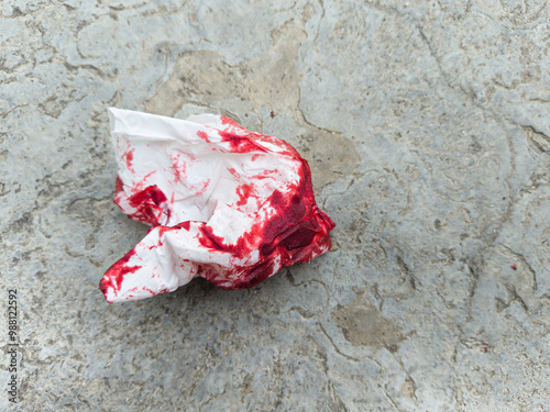 Crumpled bloody tissue paper on the ground concept murder, crime, accident, incident, emergency