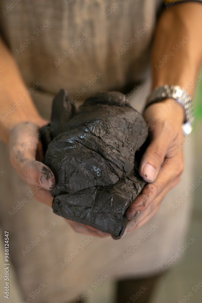 Hand holding clay in pottery workshop class Hand holding clay in pottery workshop class