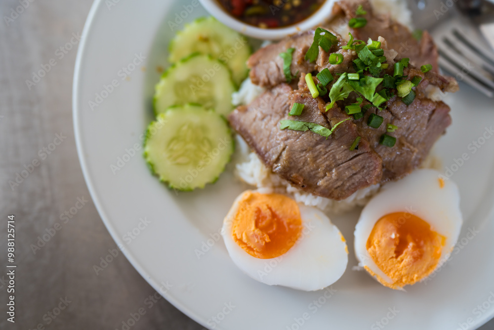Slice of stewed pork eaten with rice served with boiled egg and cucumber sprinkled with coriander. Close up Slice of stewed pork eaten with rice served with boiled egg and cucumber sprinkled with coriander. Close up