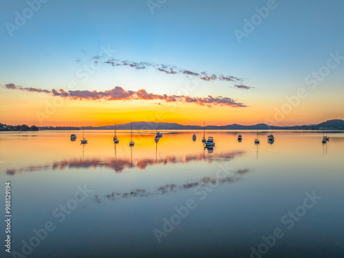 Autumn sunrise over the bay with boats and reflections photo