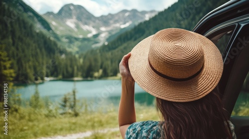 Happy woman holding hat outside open car window