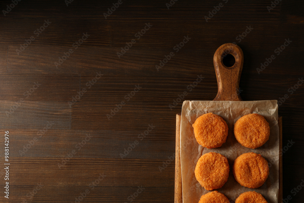 Fried mozzarella on a wooden board on a dark background Fried mozzarella on a wooden board on a dark background