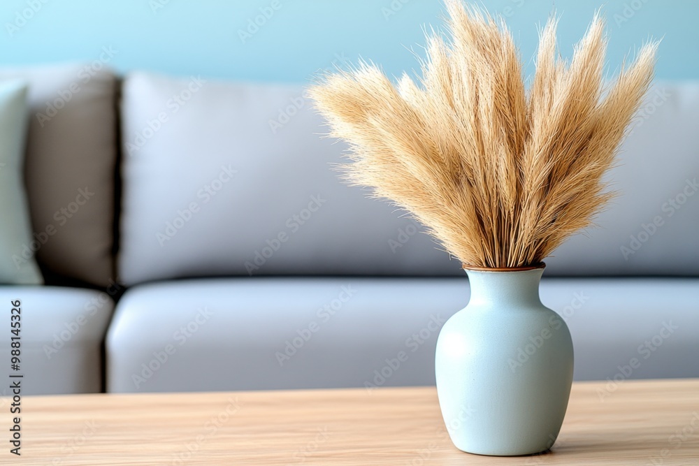Naklejka premium A close-up of a vintage vase, filled with dried pampas grass, placed on a wooden coffee table