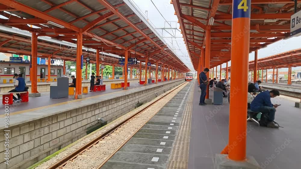 Bekasi, Indonesia on 3 February 2024. A bustling train station platform in Indonesia, featuring a vibrant orange-and-gray overhead structure. Bekasi, Indonesia on 3 February 2024. A bustling train station platform in Indonesia, featuring a vibrant orange-and-gray overhead structure.