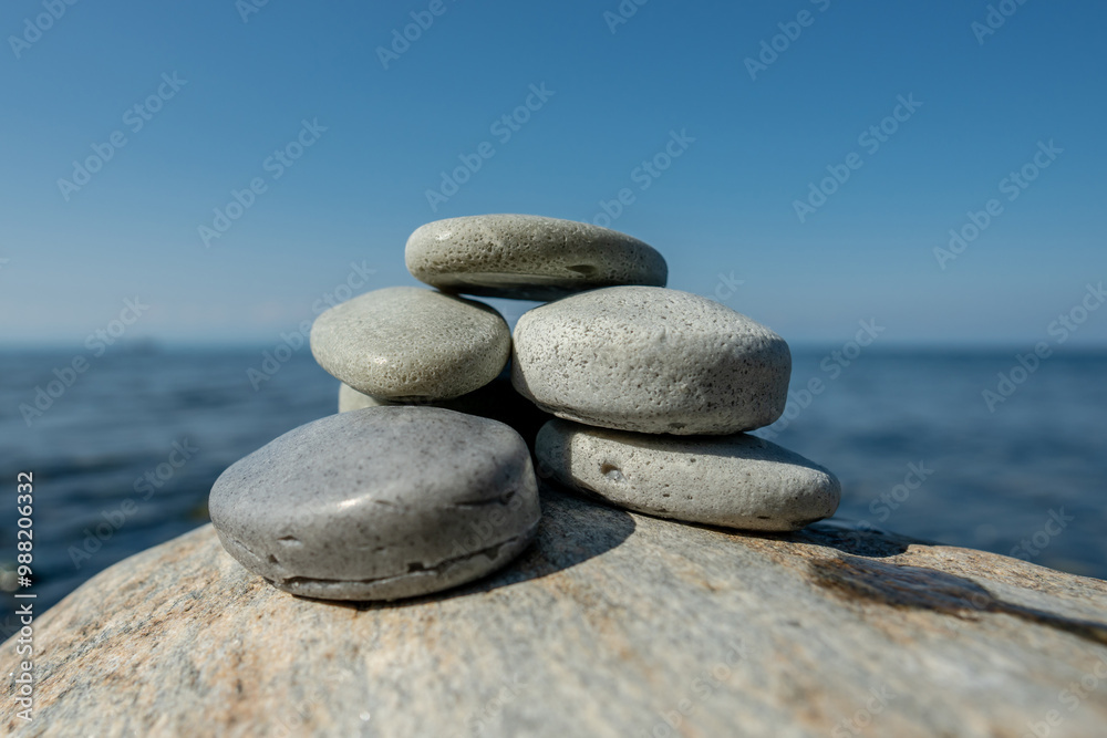 Pieces of craft soap in the shape of stones are stacked on top of each other against the background of the sea or lake. Image of organic cosmetics in a natural environment Pieces of craft soap in the shape of stones are stacked on top of each other against the background of the sea or lake. Image of organic cosmetics in a natural environment