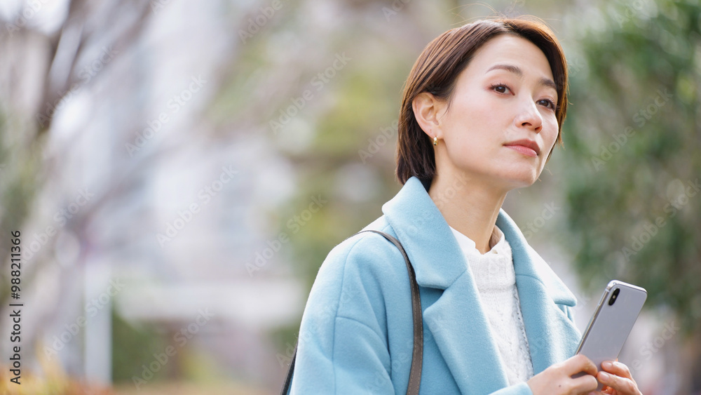 スマホを使う女性(冬服・上着・コート) スマホを使う女性(冬服・上着・コート)