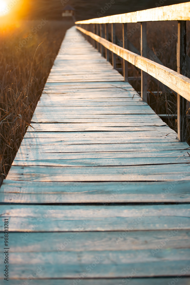 Old wooden boardwalk with a railing on the side and watchtower in the Sic reed reservation, Cluj , Romania Old wooden boardwalk with a railing on the side and watchtower in the Sic reed reservation, Cluj , Romania