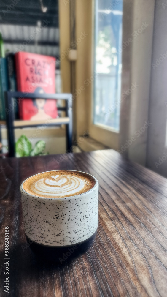 a cup of coffee on the table with a blurred bookshelf background a cup of coffee on the table with a blurred bookshelf background