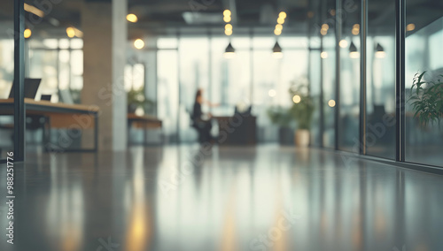 This is a blurry image of an office with a polished floor and a person working at a desk