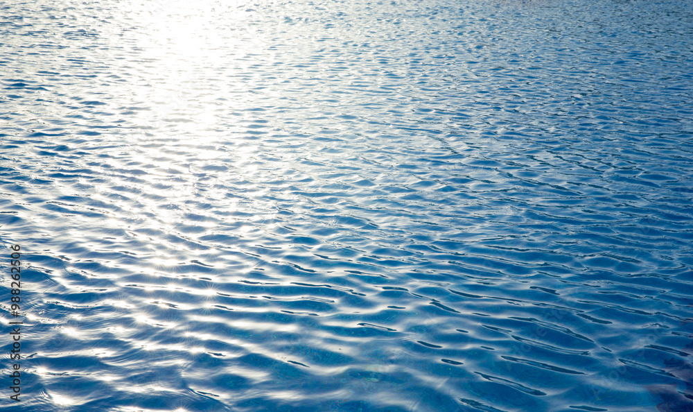 Fototapeta premium Water in swimming pool rippled water detail background. Blue in the water in the swimming pool.