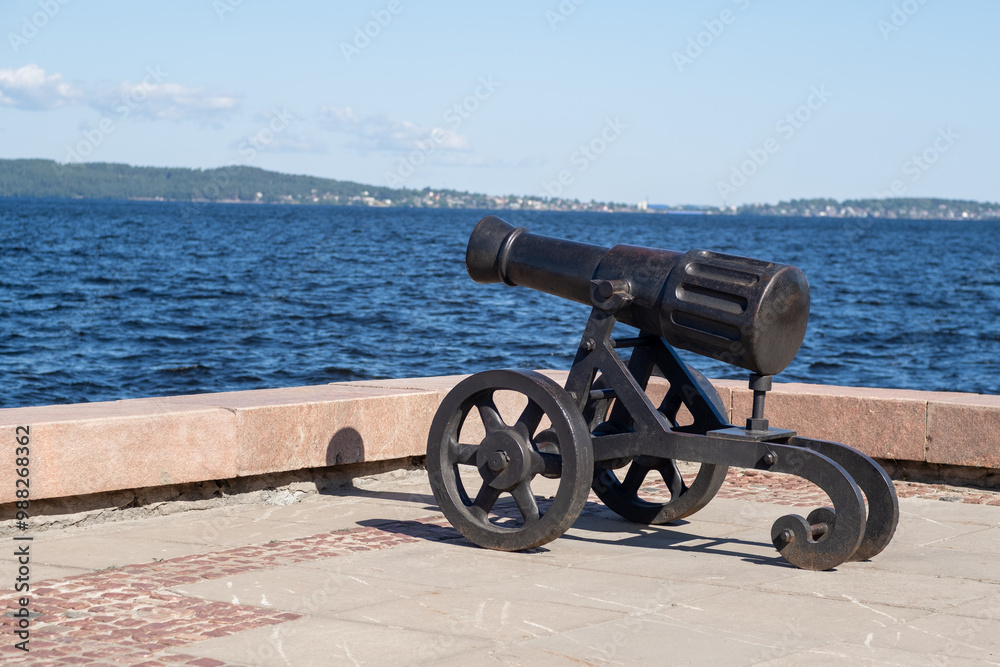 The cannon stands prominently on the shores of Lake Onega, overlooking the water and highlighting local historical significance The cannon stands prominently on the shores of Lake Onega, overlooking the water and highlighting local historical significance