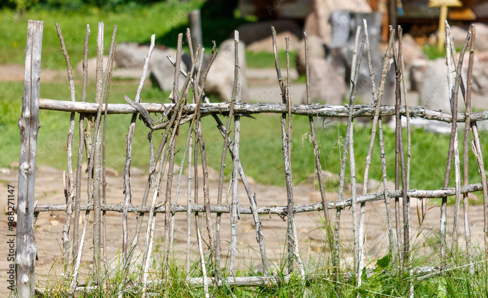 A wooden fence made of sticks and branches A wooden fence made of sticks and branches