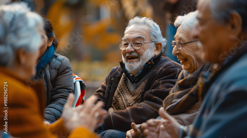 Senior man gets offended when friends make a joke about him. Happy old people having fun at a retirement home. Group of elderly men and women sitting in a circle and laughing at the