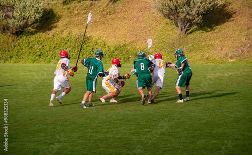 Far shot of six unidentifiable young lacrosse players in action photo