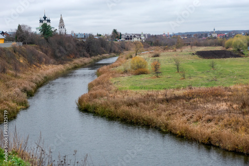 View of the Kamenka River and the Cathedral of the Nativity of the Blessed Virgin Mary in the Kremlin of Suzdal on an autumn day, Vladimir region, Russia photo