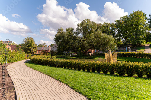 Scenic garden pathway winding through lush greenery on a sunny day in a serene park