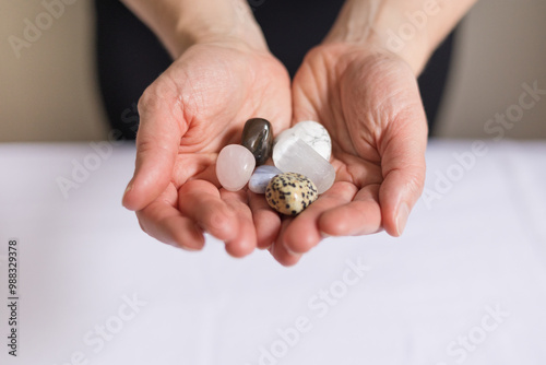 Close up of woman's hands holding crystals for energy healing Reiki