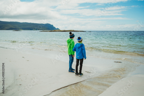 Two boys on Grotlesanden Beach in Storholmen, Norway, at the sea photo