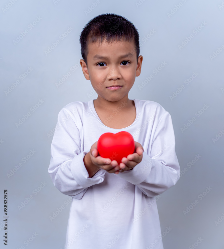 Portrait of Asian little boy child holding red heart sign on white background. Portrait of Asian little boy child holding red heart sign on white background.
