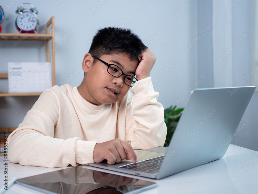 Boy using computer for learning and stressed about online learning, Virtual internet online class from school teacher by remote meeting, Homeschooling and education concept, online education concept. Boy using computer for learning and stressed about online learning, Virtual internet online class from school teacher by remote meeting, Homeschooling and education concept, online education concept.