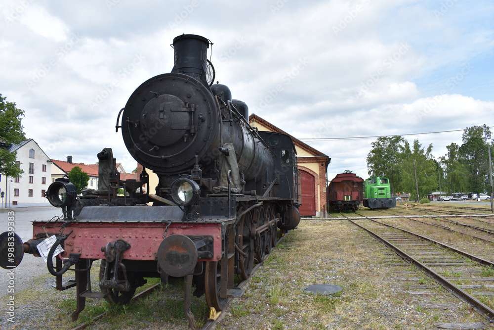 Alte Dampflok vor Lokschuppen mit Waggons in Nora Alte Dampflok vor Lokschuppen mit Waggons in Nora