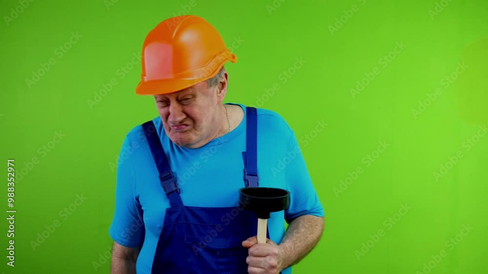 Senior worker in overalls smelling something stinky with disgust feeling bad smell waving his hand. Senior worker in overalls smelling something stinky with disgust feeling bad smell waving his hand.