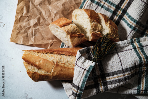 french baguette fresh, cut in slices, in kitchen textile cloth, rustic sryle photo