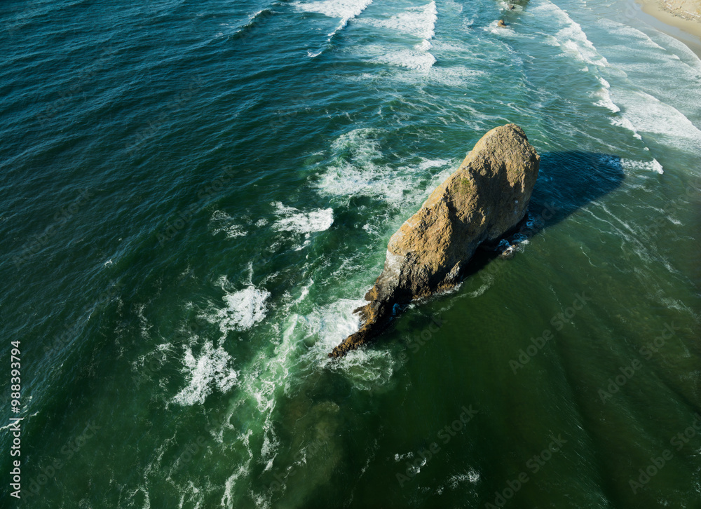 Naklejka premium A rocky island sits in the middle of the ocean