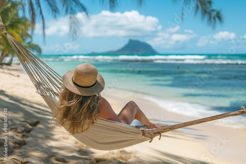 Fototapeta Naklejka Na Ścianę i Meble -  A woman is relaxing on a beach with a hammock. The beach is calm and peaceful, and the woman is enjoying the view of the ocean