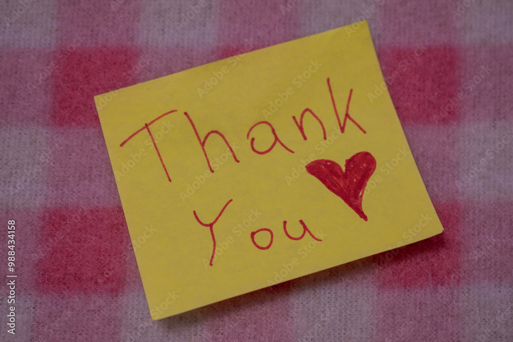 Thank you note lying on pink blanket. Thank you note lying on pink blanket.