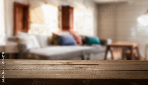 A wooden table top with a blurred background of a living room.