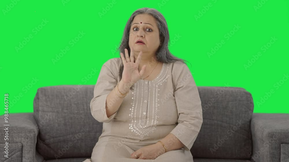 Upset Indian old woman slapping her head Green screen