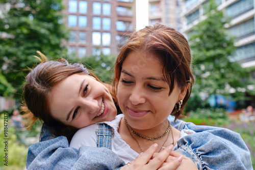 Affectionate woman embracing girlfriend at paark photo