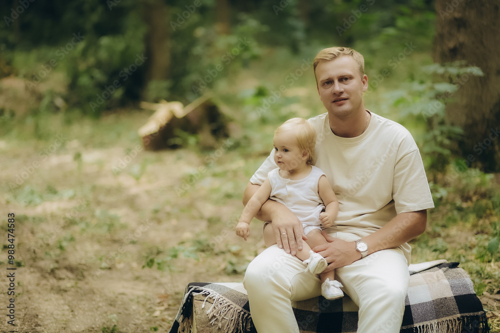 A father holds his daughter in his arms in the forest A father holds his daughter in his arms in the forest
