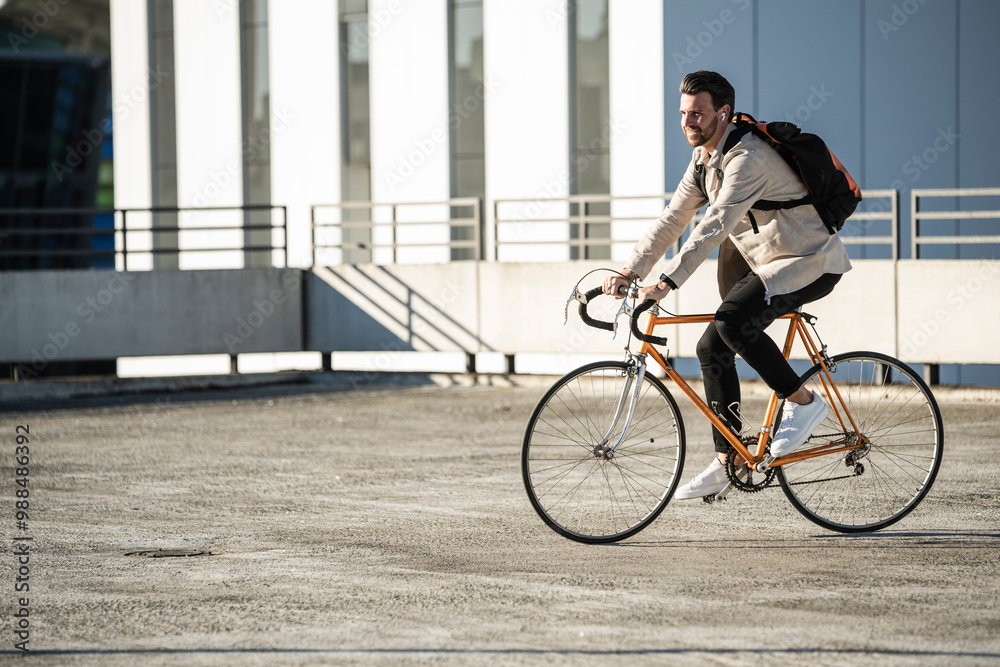 Man with backpack riding bicycle in parking lot Man with backpack riding bicycle in parking lot